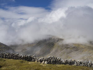 Steinmauer auf Berg gegen bewölkten Himmel, Schottland, UK - HUSF00074