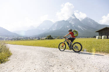 Boy riding e-mountain bike in the mountains - FKF03530