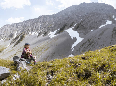 Mädchen macht eine Pause während einer Wanderung in den Bergen, lizenzfreies Stockfoto