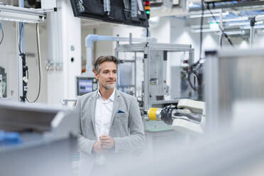 Portrait of a confident businessman in a modern factory - DIGF07841