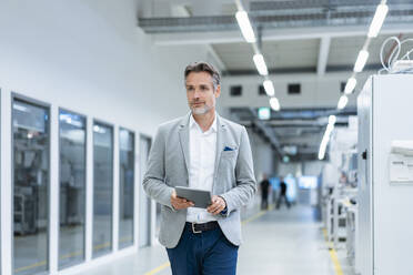 Businessman with tablet in a modern factory - DIGF07854