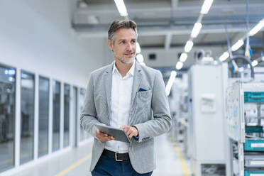 Businessman with tablet in a modern factory - DIGF07855