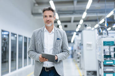 Businessman with tablet in a modern factory - DIGF07856