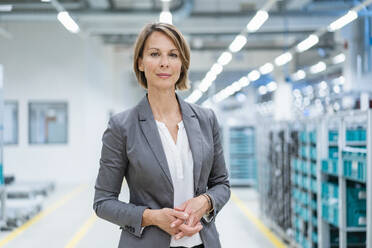 Portrait of a confident businesswoman in a modern factory - DIGF07867