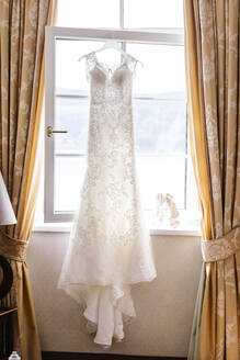 Hochzeitskleid, das zu Hause vor dem Fenster hängt - DAWF00900