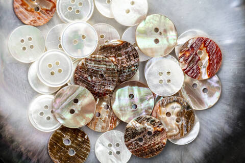 Close-up of buttons made with shells on table in workshop stock photo