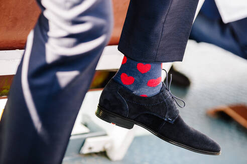 Low section of man wearing socks with heart shape in ceremony - DAWF00949