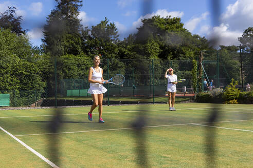 Reife Frauen bei einem Tennisspiel auf einem Rasenplatz - WPEF01719