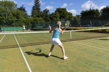 Reife Frauen bei einem Tennisspiel auf einem Rasenplatz - WPEF01722