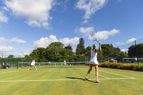 Reife Frauen bei einem Tennisspiel auf einem Rasenplatz - WPEF01723