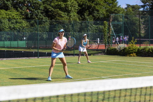 Reife Frauen bei einem Tennisspiel auf einem Rasenplatz - WPEF01724