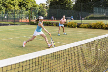 Reife Frauen bei einem Tennisspiel auf einem Rasenplatz - WPEF01752