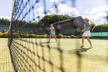 Reife Frauen bei einem Tennisspiel auf einem Rasenplatz - WPEF01755