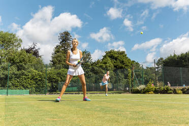 Reife Frauen bei einem Tennisspiel auf einem Rasenplatz - WPEF01756