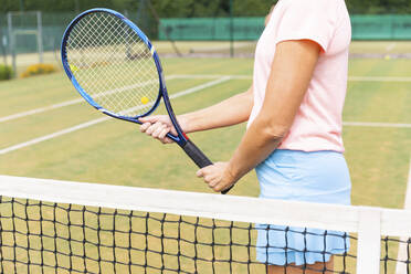 Tennisspielerin hält den Schläger auf einem Rasenplatz - WPEF01769