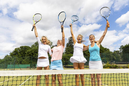 Glückliche Tennisspielerinnen feiern den Sieg auf dem Rasenplatz - WPEF01775