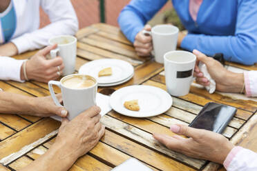 Nahaufnahme einer Gruppe von Frauen, die sich nach einem Spiel in einem Cafe im Tennisclub unterhalten - WPEF01794