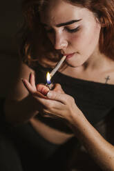 Junge Frau, die zu Hause Marihuana raucht - LJF00650