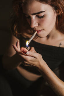 Junge Frau, die zu Hause Marihuana raucht - LJF00650
