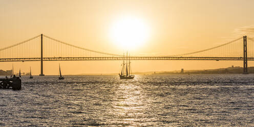 25. April Brücke über den Tejo vor orangefarbenem Himmel in Lissabon, Portugal - WDF05387