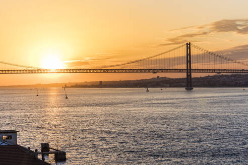 25. April Brücke über den Fluss Tejo gegen den Himmel bei Sonnenuntergang in Lissabon, Portugal - WDF05388