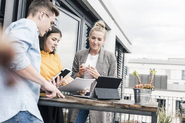 Lässige Geschäftsleute treffen sich auf der Dachterrasse - UUF18564