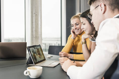 Colleagues having a video conference in conference room stock photo