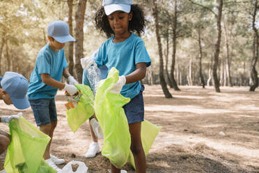 Eine Gruppe von Kindern sammelt freiwillig Müll in einem Park - JCMF00108