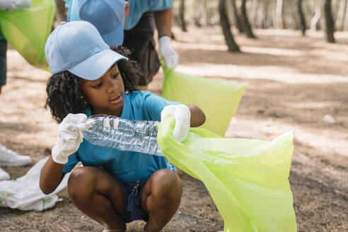 Eine Gruppe von Kindern sammelt freiwillig Müll in einem Park - JCMF00110