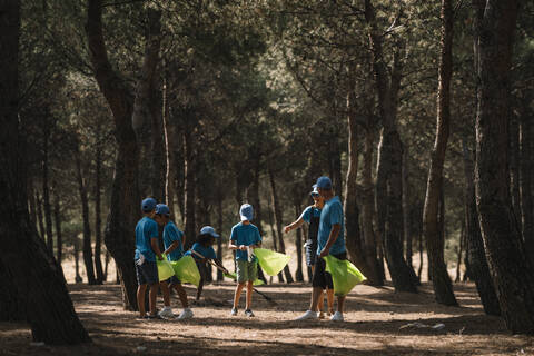 Group of volunteering children collecting garbage in a park stock photo