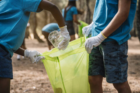 Close-up of volunteering children collecting garbage in a park stock photo