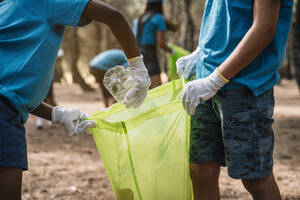 Nahaufnahme von Kindern, die freiwillig Müll in einem Park sammeln - JCMF00113