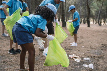 Eine Gruppe von Kindern sammelt freiwillig Müll in einem Park - JCMF00119