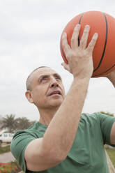 Hispanischer älterer Mann spielt Basketball im Freien - BLEF13901