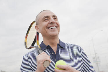Hispanischer älterer Mann mit Tennisschläger und Ball - BLEF13902