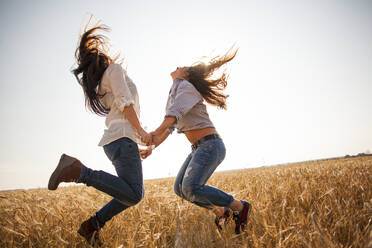 Caucasian women dancing in rural field - BLEF13912