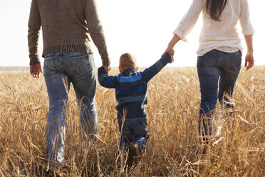 Caucasian family walking in rural field - BLEF13922