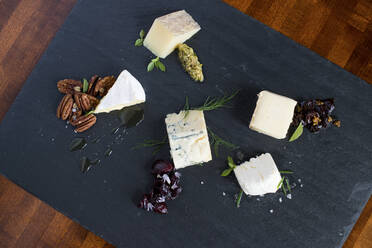 Cheese and herbs on cutting board - BLEF13926