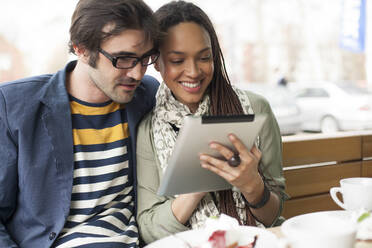 Couple using digital tablet in cafe - BLEF14012