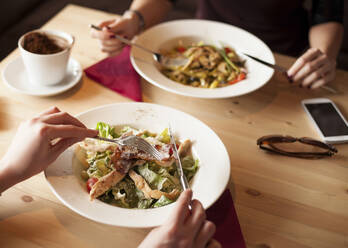 Close up of friends eating salads in cafe - BLEF14017