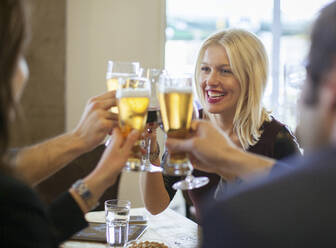 Freunde stoßen mit Bier im Café an - BLEF14024