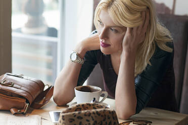 Frau sitzt allein in einem Cafe - BLEF14028