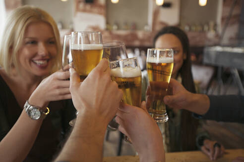 Freunde stoßen mit Bier im Café an - BLEF14030