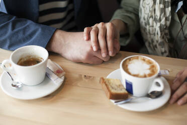 Couple holding hands in cafe - BLEF14036