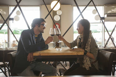 Ehepaar stößt mit Wein im Café an - BLEF14054