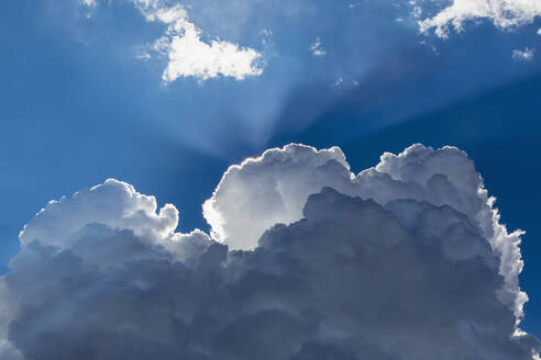 Sonnenstrahlen, die durch Wolken am blauen Himmel scheinen - BLEF14096