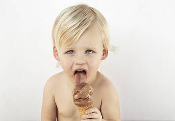 Kaukasischer Junge leckt Schokolade Eiswaffel - BLEF14107
