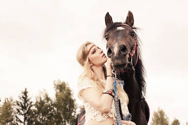 Caucasian woman petting horse outdoors - BLEF14131