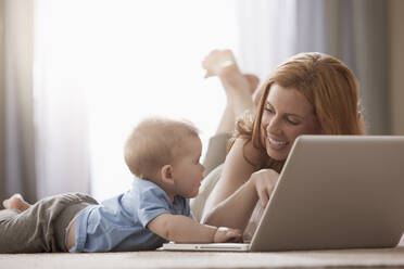 Caucasian mother and son using laptop on floor - BLEF14162