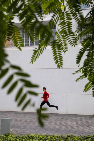 Junge Athletin beim intensiven Lauftraining in der Stadt, lizenzfreies Stockfoto